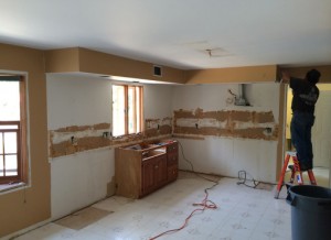 Contractor tearing down cabinets in kitchen to open up space