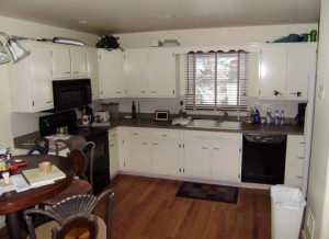 Kitchen with outdated white cabinetry and sink