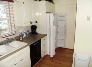 View of kitchen with cramped space around fridge