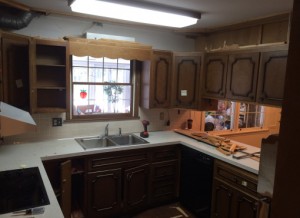 Cramped kitchen with outdated cabinetry and counters