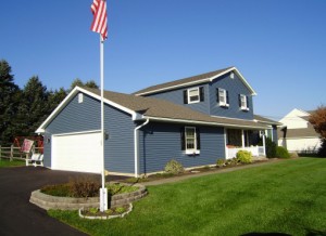 Side view of house with brand new blue siding installed